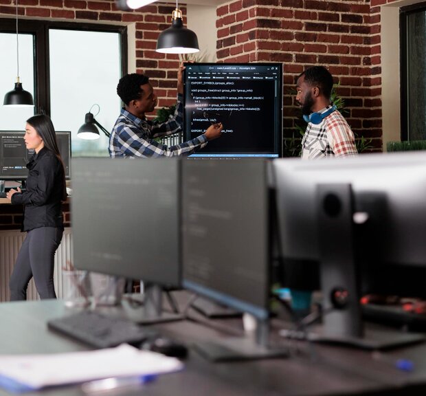 Employees in an office setting, utilizing computers to enhance productivity in IT service tasks and projects